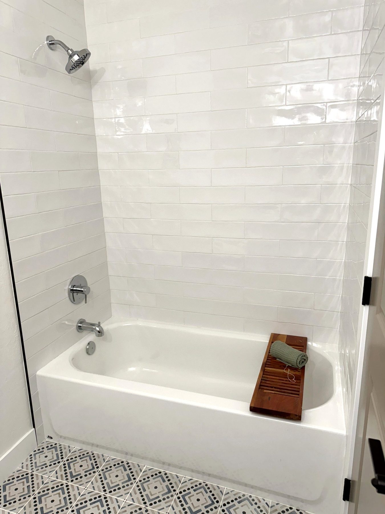 White tile tub and shower with patterned floor tile