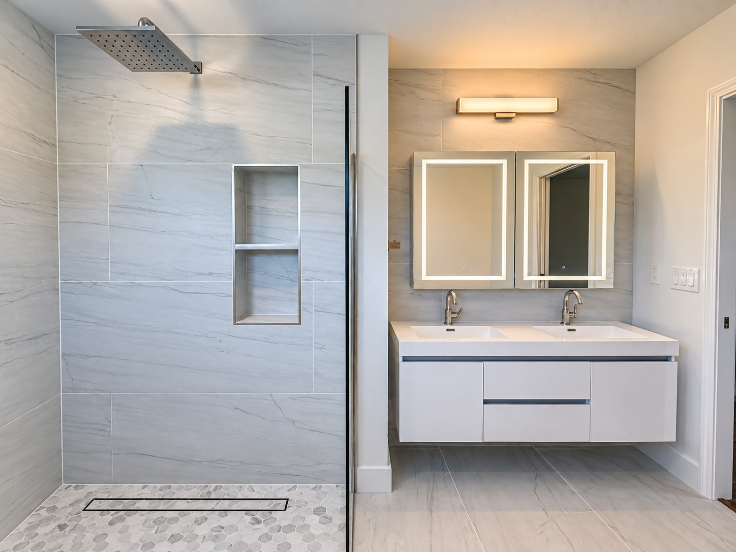 Primary bathroom view showing shower niche and double vanity