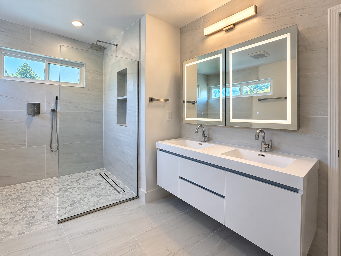 Floating double vanity and illuminated mirrors in a Castro Valley bathroom